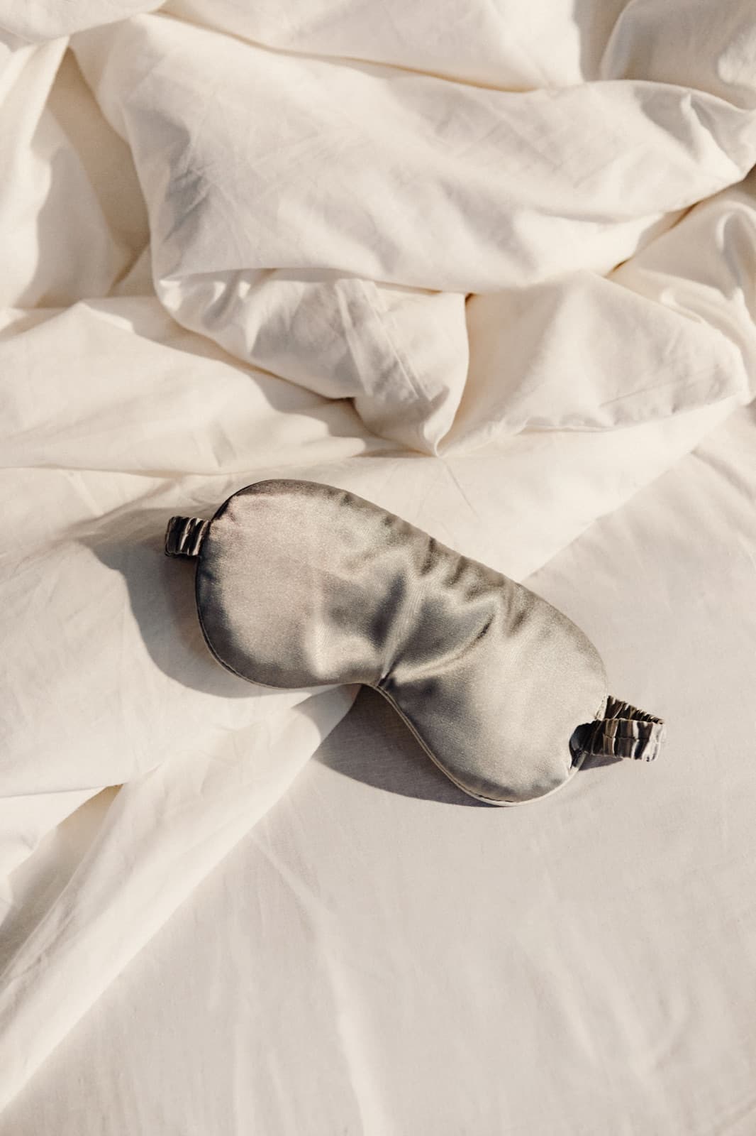Silk sleep mask on white bedding