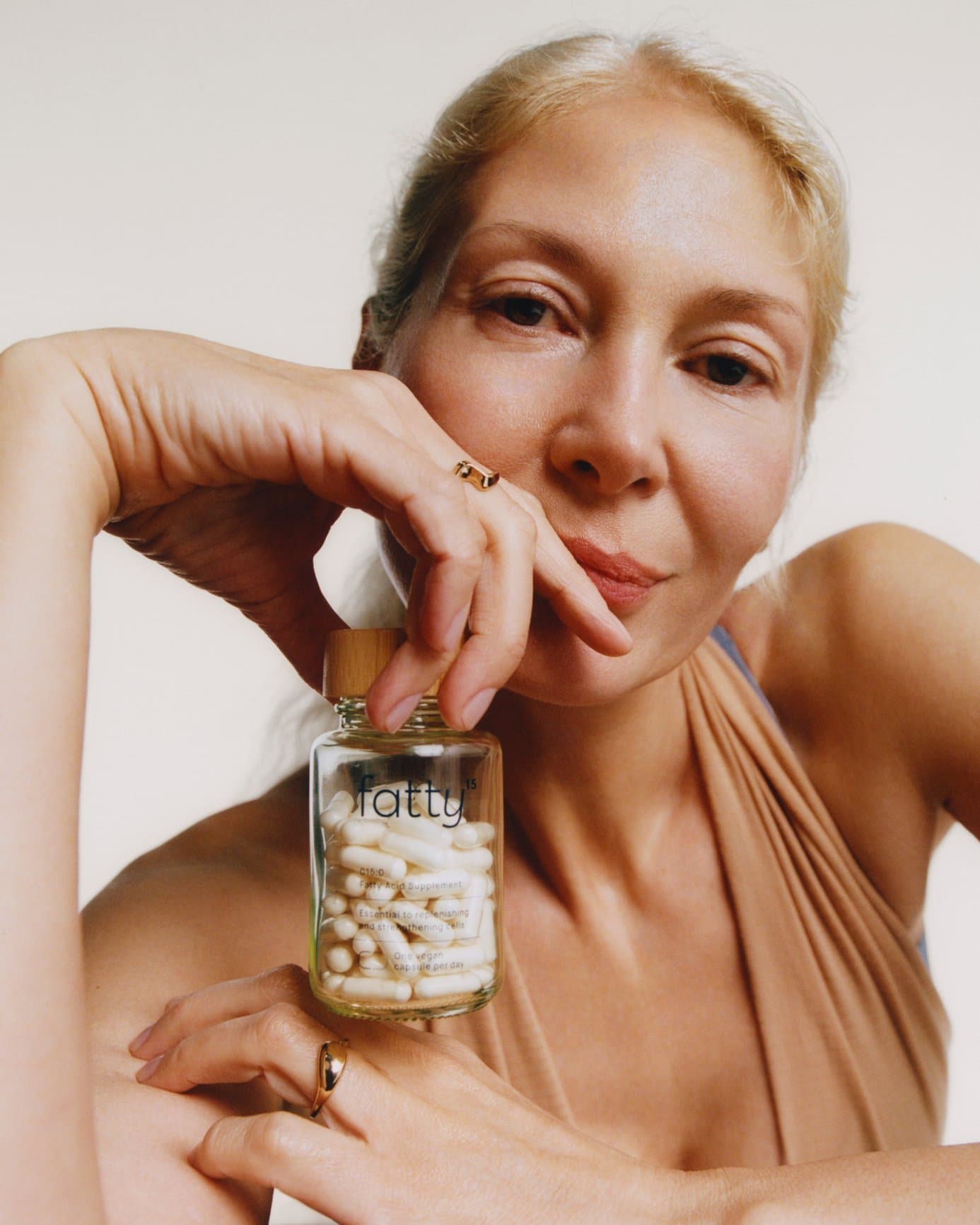 Woman holding a jar of Fatty15 capsules